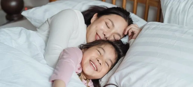 Mother and daughter resting in bed after relocating with some of the best local movers DC area has.