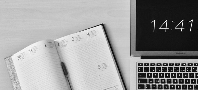 A planner and MacBook Air on a table.