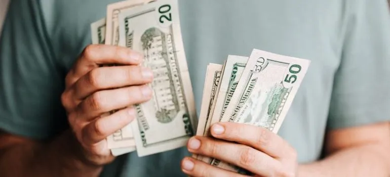 a man counting money to pay for the reliable movers in DMV area