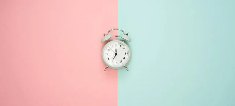 A clock on a pink and blue surface.