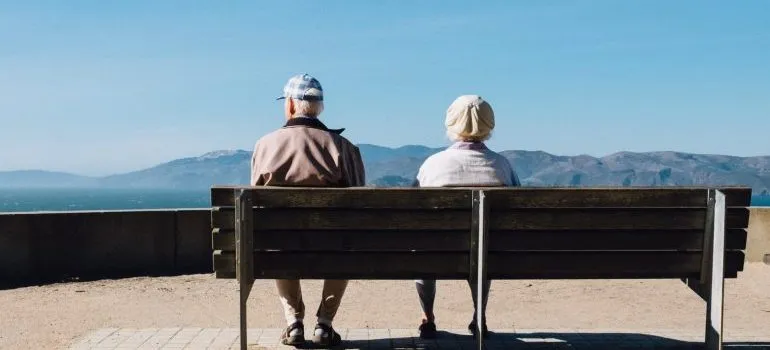 Two seniors sitting on a bench enjoying the wonderful view