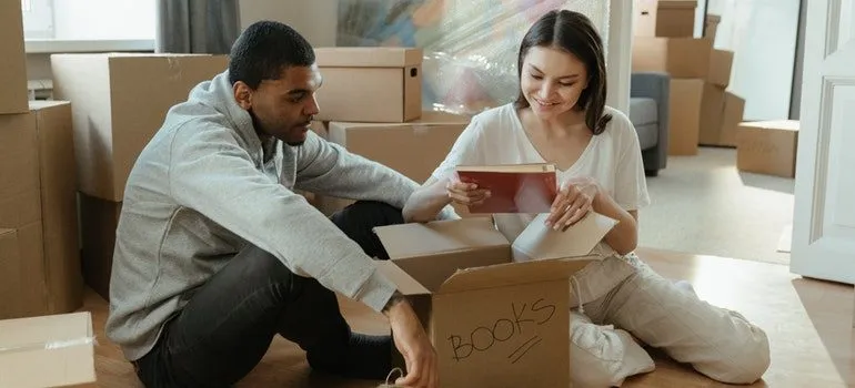 a man and a woman unpacking surrounded by boxes