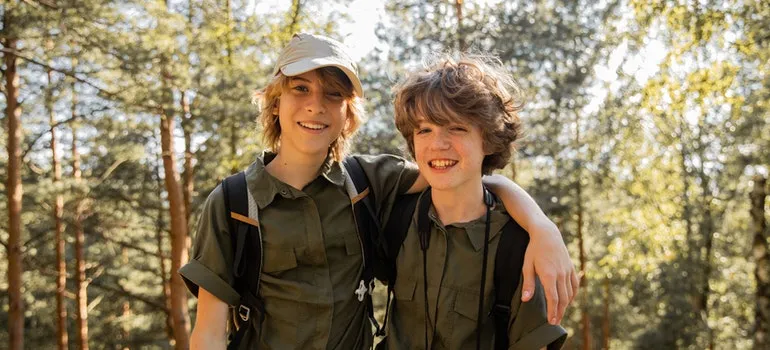 Two boys hiking across a forest.
