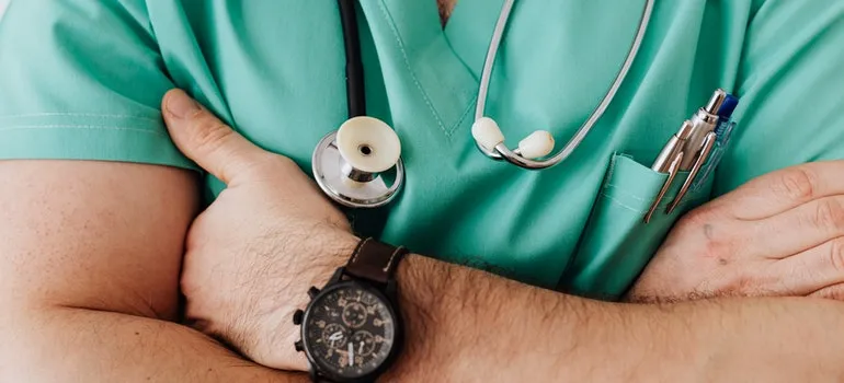 A doctor has crossed his hands.