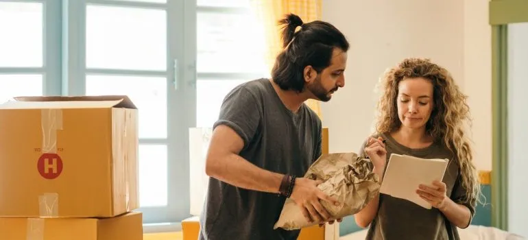 Couple checking out the packing checklist in order to pack before moving to Olney MD