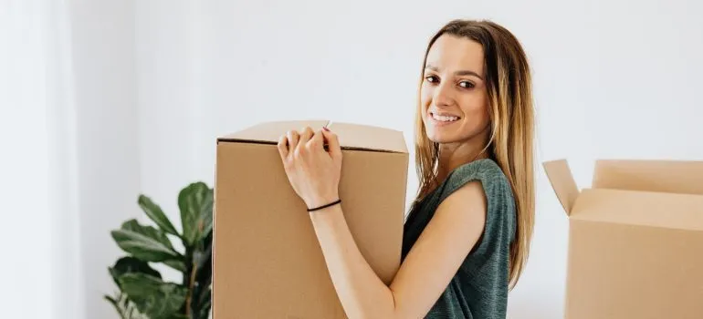 The girl holding the box with the packed things.