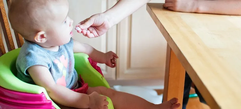 baby in green and purple chair
