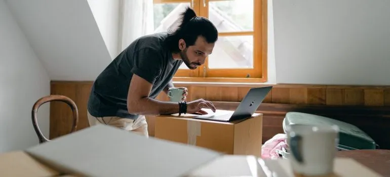 a man playing music on the laptop while decluttering