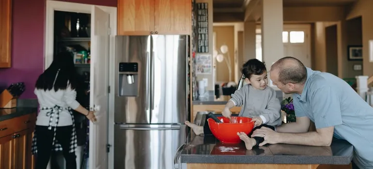 Parents and baby in the kitchen preparing to babyproof new home
