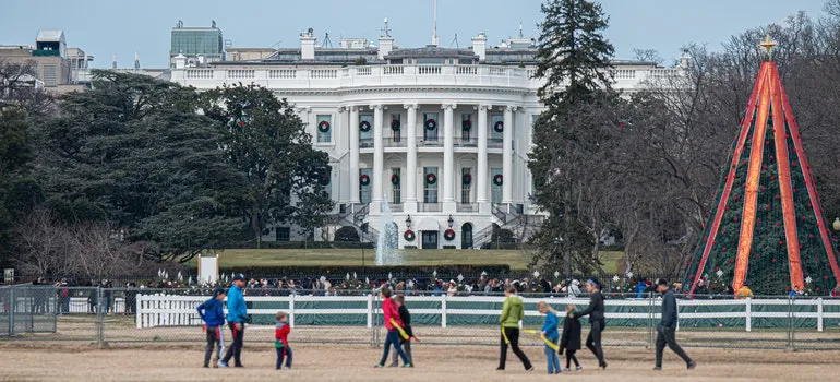 People walking near a white building