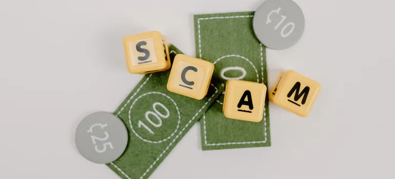 cubes with letters on them form the word "SCAM".