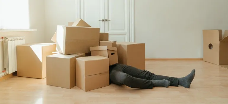 A man laying under the pile of boxes