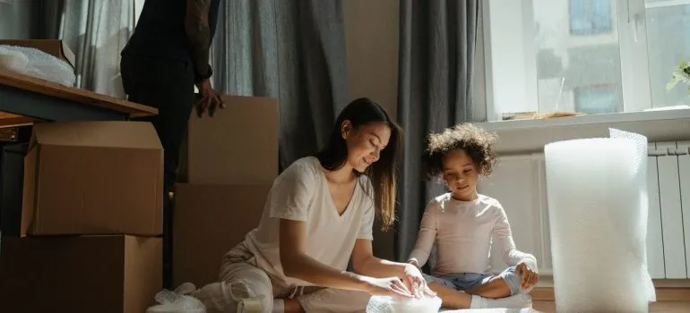 a mother packing items as her daughter looks, while the father looks from above