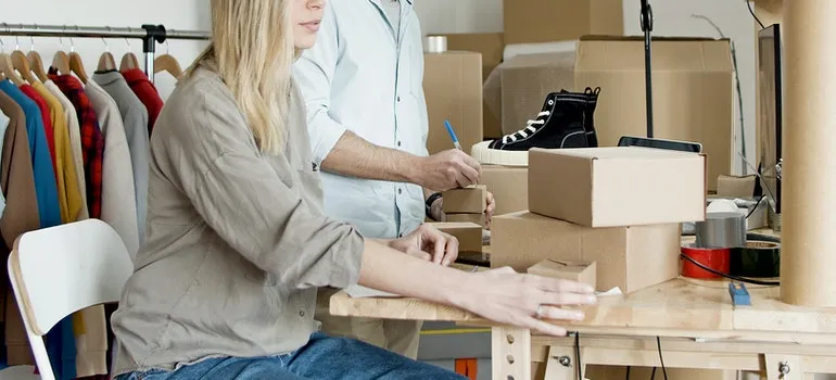A man and a women getting ready to pack for moving out of state in a week.