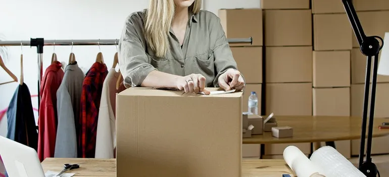 A woman labeling a box.