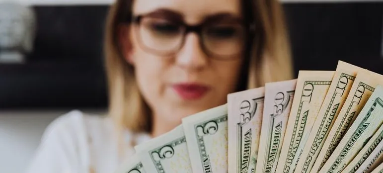a woman holding dollar bills