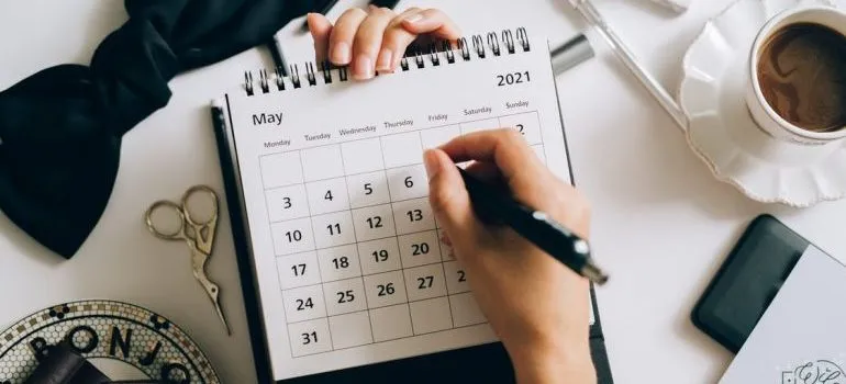 A person is writing on a calendar