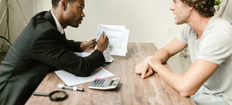 An agent showing documents to his clients