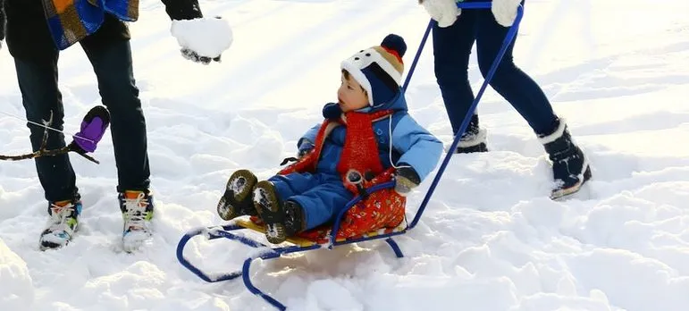 a couple and two kids playing an the snow