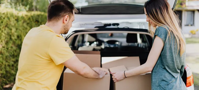 a couple placing cardboard boxes inside the car trunk as should you when finishing packing your home before moving from Potomac to DC