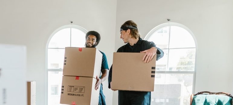 two movers carrying boxes