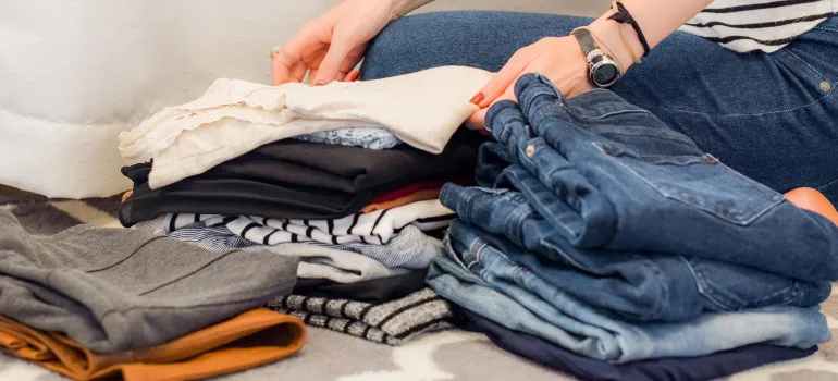 a woman going through her clothes before packing them