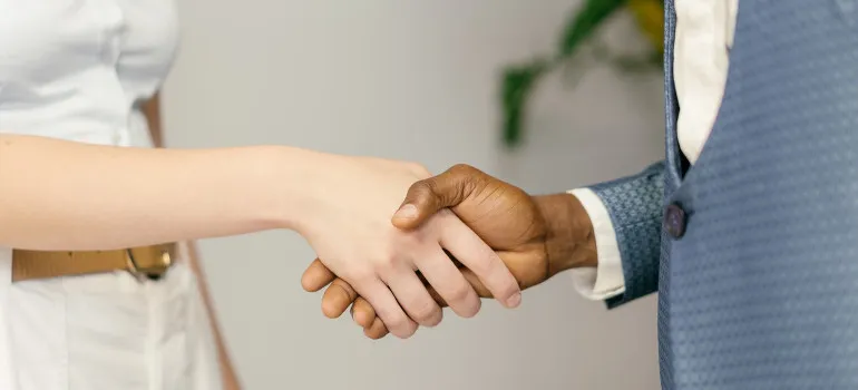 Person shaking hands after hiring movers to wrap fragile items for long haul moves