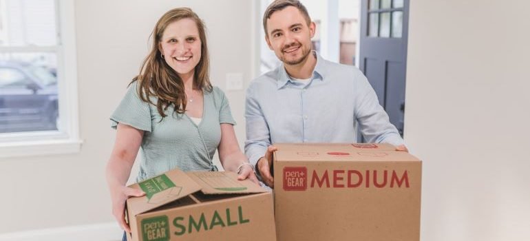 man and a woman holding boxes