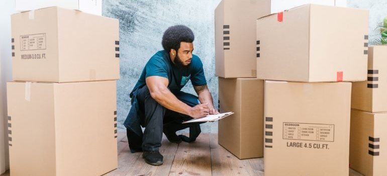 a guy reading labels on boxes