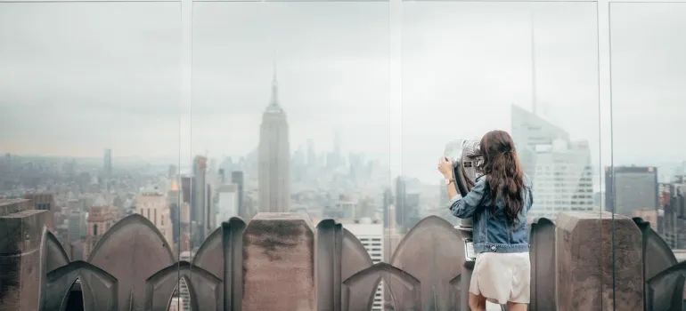 woman looking at NYC from building