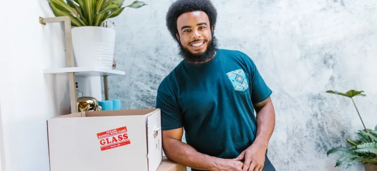 a mover leaning on a box while taking a break from working