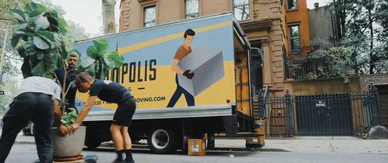 men bringing stuff into a truck