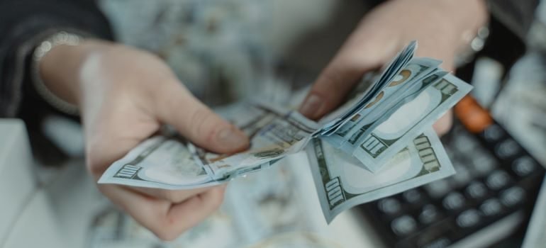 a person counting US Dollars