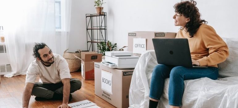 man and woman labeling boxes for moving