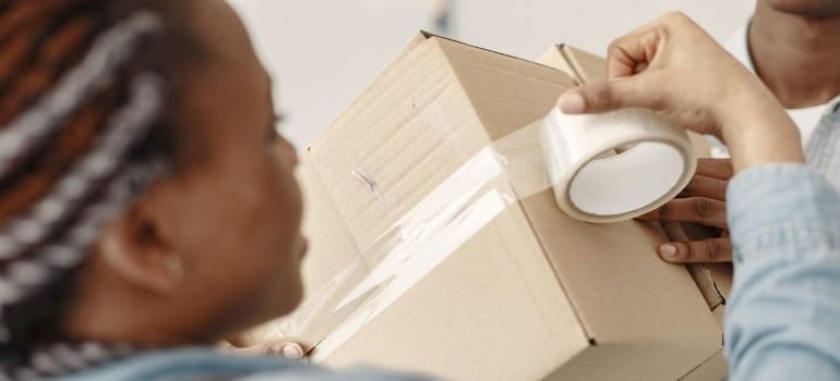a woman taping down a box