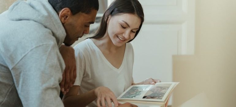 Couple looking at photos while moving - you should consider downsize before relocation to Washington DC -