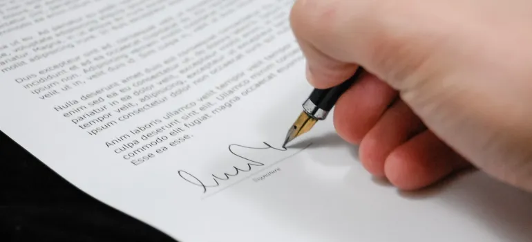 A hand signing a paper