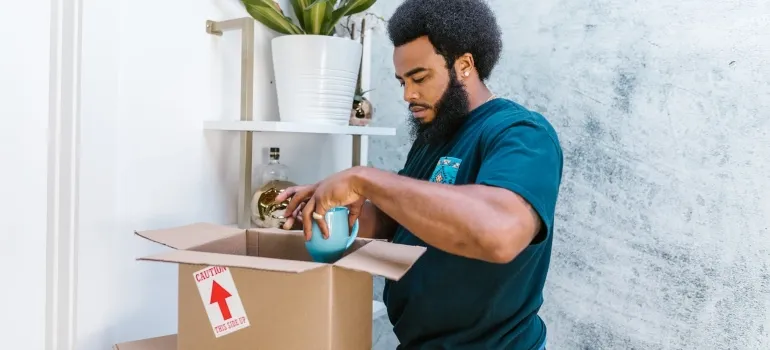 a person packing items inside a cardboard box