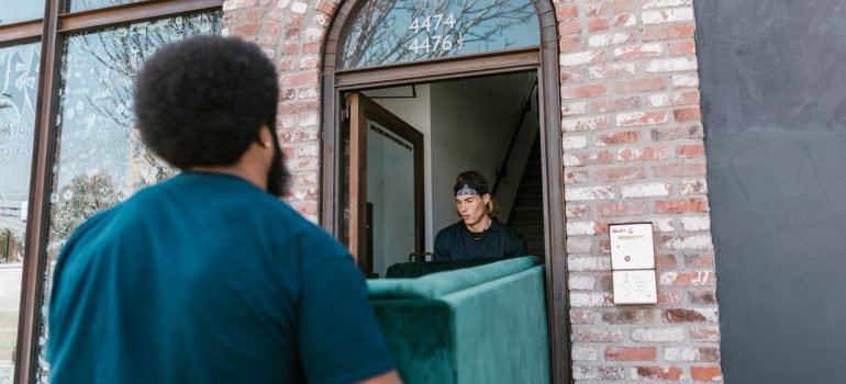 Two movers carrying heavy sofa
