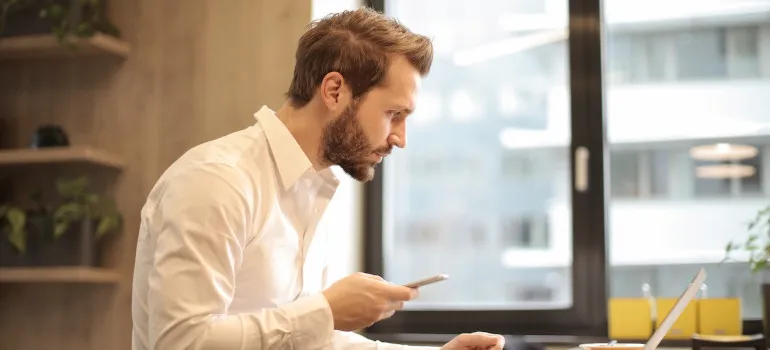 Man using a laptop to research a moving company before deciding on moving in or out of Bethesda
