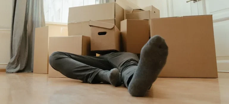 A man lying on the ground under the boxes
