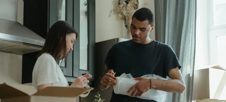 couple packing their items before moving to NYC on budget