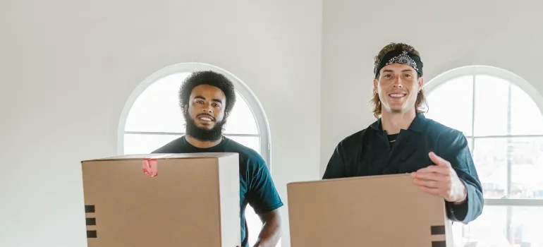 two movers holding boxes