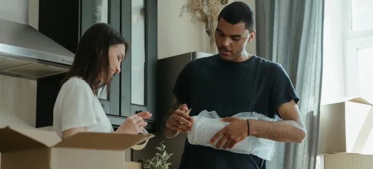 Couple packing and labeling their items after reading the packing guide for beginners