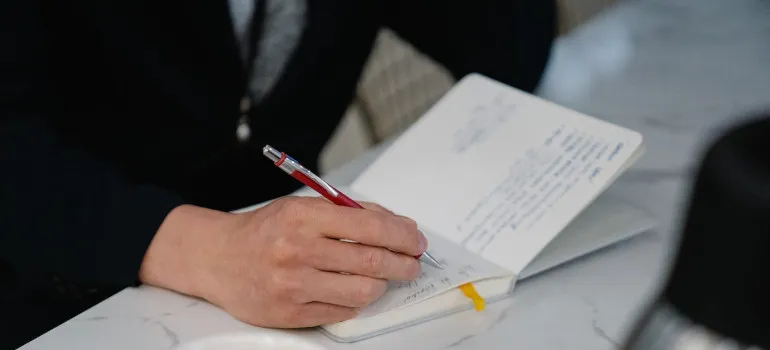 Man writing down a plan on how to pack your bag of essentials when moving to Washington DC