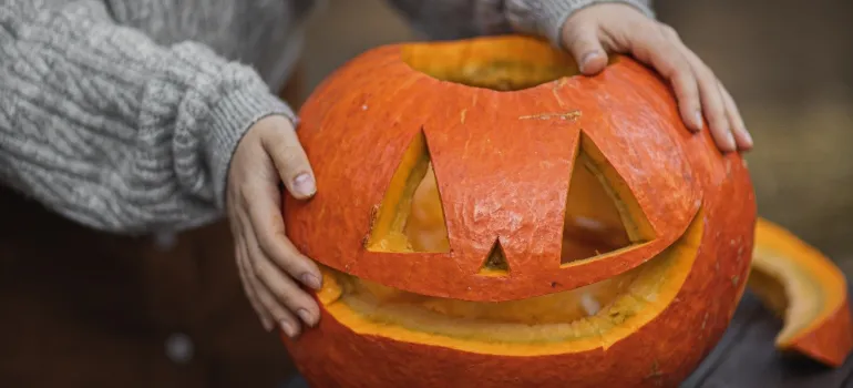 person holding a carved pumpkin