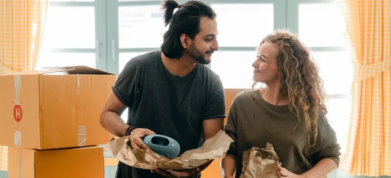 couple smiling at each other while packing