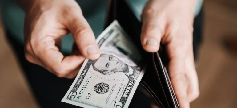 Picture of a person taking out money counting for moving to McLean after a job loss