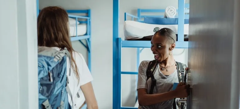 Two girls opening the room to their dorm after reading how to organize a move if you are a student in Maryland