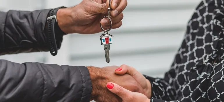 two people holding keys after choosing among the best places to buy a house in Maryland
